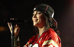 Billie Eilish on stage smiling 2025